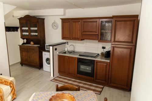 a kitchen with wooden cabinets and a table in a room at Casa vacanza La Seggiara in San Giovanni Incarico