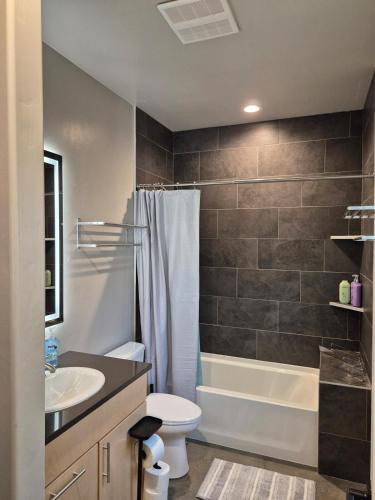 a bathroom with a toilet and a tub and a sink at Bluff 11 Professional Housing in Delta