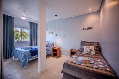 a bedroom with two beds and a window at Los Hermanos Residencial in Florianópolis