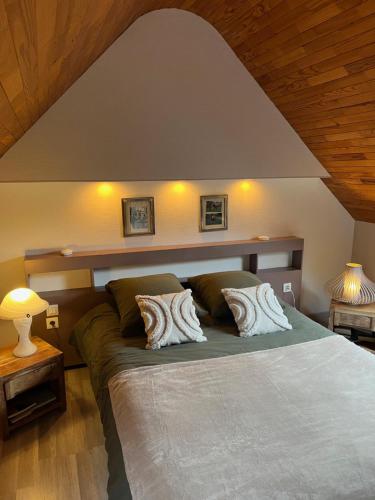 a bedroom with a large bed with two pillows at Gîte de La Ferme du Syet in Minihy-Tréguier