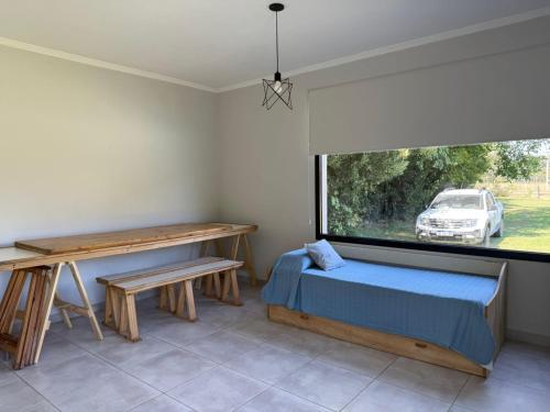 a bedroom with a bed and a desk and a window at Las moras saladillo in Saladillo
