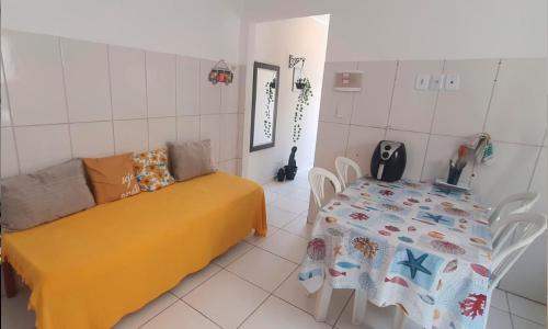 a room with a table and a bed and a table and chairs at Flat Kactus in Itacaré
