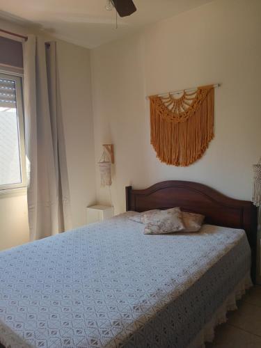 une chambre avec un lit avec une couette bleue et une fenêtre dans l'établissement Apartamento Capão Novo, à Capão Novo