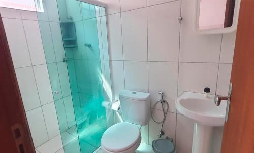 a bathroom with a shower and a toilet and a sink at Flat Kactus in Itacaré