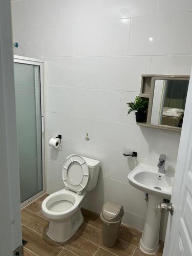 a bathroom with a toilet and a sink at Eastern Breeze in Hainamosa