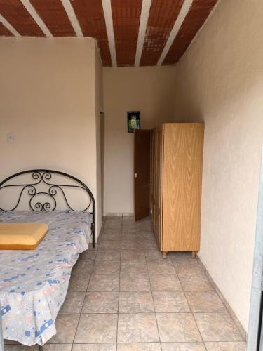 a bedroom with a bed and a wooden cabinet at Sítio Bela Vista in Areado