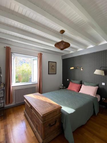 a bedroom with a large bed and a window at Le jardin du Griffoul in Nébias