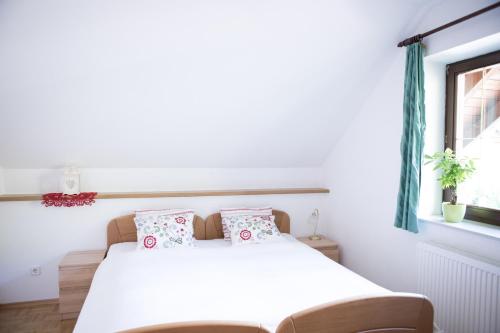 a white bedroom with a bed and a window at Ferienhaus Sara - Kärnten Card im Sommer inklusive in Bad Kleinkirchheim
