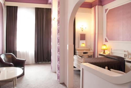 een hotelkamer met een woonkamer en een slaapkamer bij Hotel Dacia in Lugoj