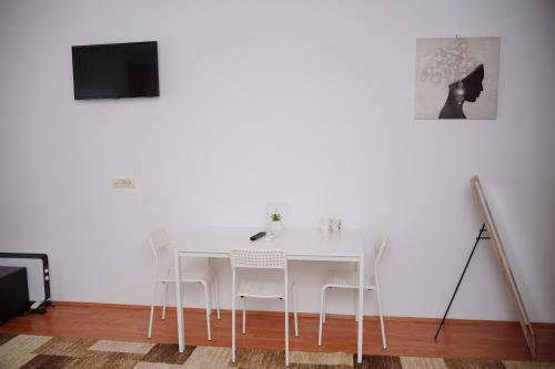 a white dining room with a white table and white chairs at Vila Madera Priboj in Čitluk