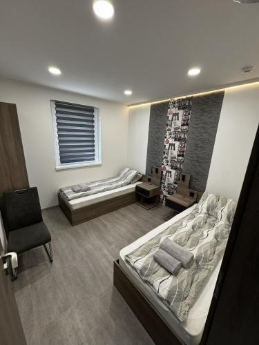 a room with two beds and a chair in it at Silver Chill Apartman in Abádszalók