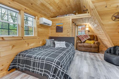 Un dormitorio con una cama en una cabaña de madera. en 5 Mi to Wine Trails Finger Lakes Tiny Home, en Ovid