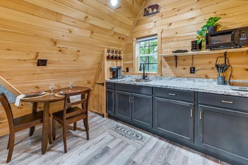una cocina con mesa y fregadero en una cabaña en 5 Mi to Wine Trails Finger Lakes Tiny Home, en Ovid