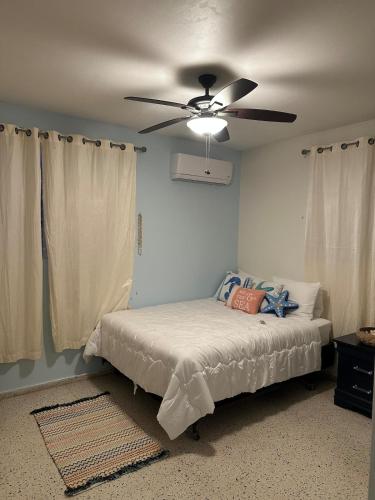 ein Schlafzimmer mit einem Bett und einem Deckenventilator in der Unterkunft Casa Bayaverde in Bayamon