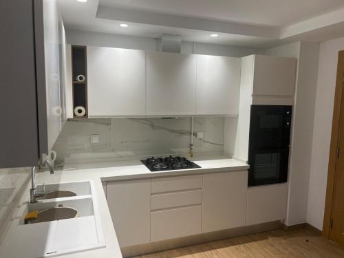a white kitchen with a sink and a stove at Le Relais Résistance Luxury in Sousse