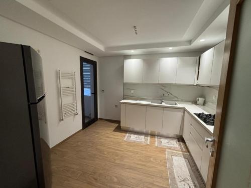 a kitchen with white cabinets and a wooden floor at Le Relais Résistance Luxury in Sousse