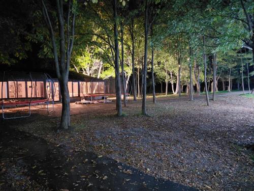 un grupo de árboles en un parque con una valla en HOTEL RANCHO UPLISTSIKHE სასტუმრო რანჩო უიფლისციხე, en Uplistsikhe