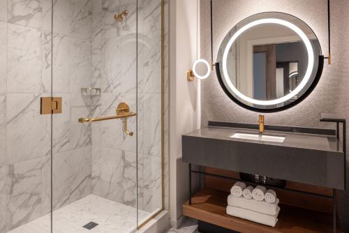 a bathroom with a shower and a sink and a mirror at Caesars Virginia, A Caesars Destination in Danville