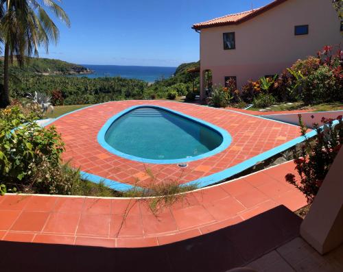 a swimming pool on a red brick walkway next to a house at Fond Bay Suites Hotel - Breathtaking Ocean Views in Micoud