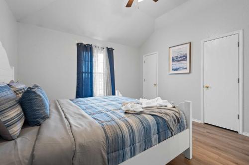 a bedroom with a bed with a blue blanket and a window at Modern 3BR Stay with Large Parking Pet Friendly in Killeen
