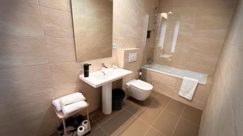 a bathroom with a sink and a toilet and a mirror at Eda7 Boutique Rooms in Sarajevo