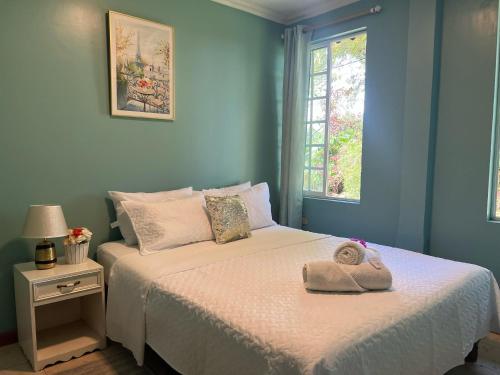 Un dormitorio azul con una cama con un sombrero encima. en Family Stay con Desayuno 7 camas 6 dormitorios, en Puyo