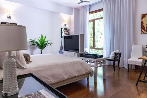a bedroom with a bed and a tv on a table at Luxe 2-Bed Golf-View Apt 1 Min to Altos de Chavon in El Infiernito