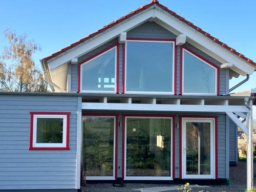 Una casa con grandes ventanas y molduras rojas. en Finkennest am Desenberg, en Warburg