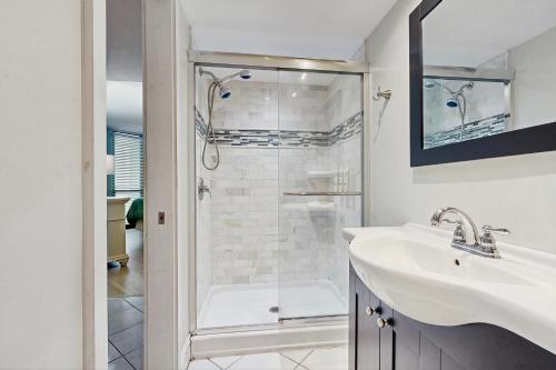 a white bathroom with a shower and a sink at Pyramid 8K in Ocean City