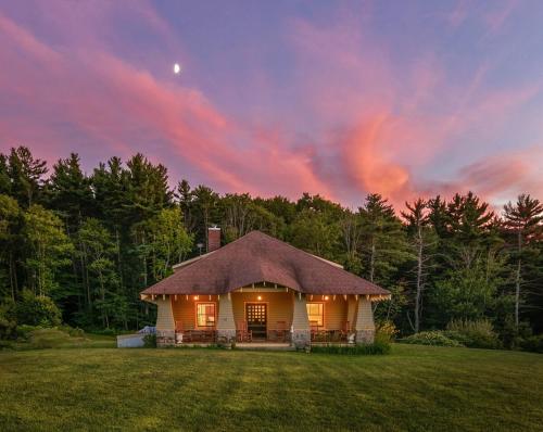 a small house in a field with a sunset at Kimball Castle Legacy - Lake Views - Near Gunstock in Gilford