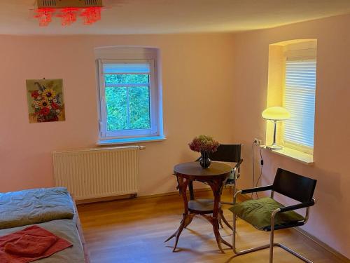 ein Wohnzimmer mit einem Tisch und einem Stuhl in der Unterkunft Kleines gemütliches Fachwerkhaus für vier Gäste in Reinhardtsdorf