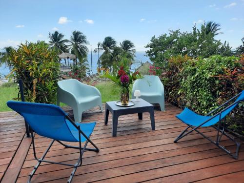 ル・ディアマンにあるTurquoise studio remarquable vue merの木製のデッキに置かれた3脚の椅子とテーブル