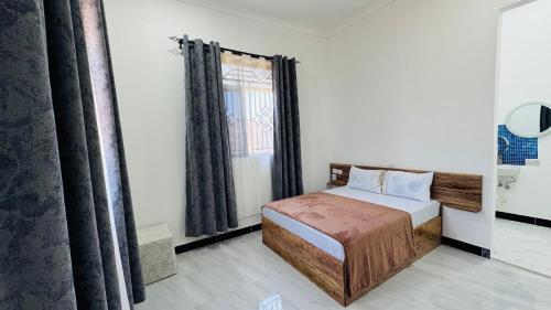 ein kleines Schlafzimmer mit einem Bett und einem Fenster in der Unterkunft Hakunamatata studio in Zanzibar City