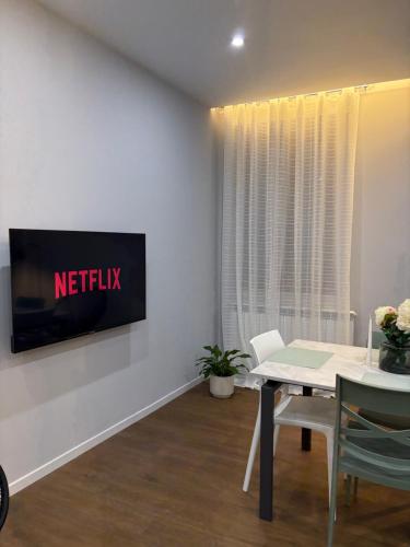 a dining room with a television on a wall at AB apartment Pistoia in Pistoia