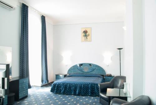 1 dormitorio con 1 cama azul y 1 silla en Hotel Dacia, en Lugoj