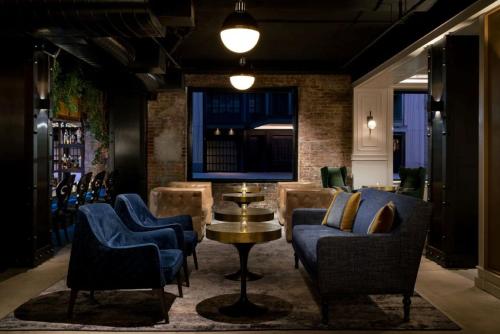 a bar with chairs and a table and a tv at Arthouse Hotel in New York