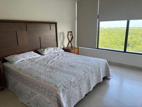 a bedroom with a bed and a large window at Baltia departamento in Mérida