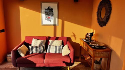 a living room with a red couch and a table at Jacaranda stylish ambiance with volcano and ocean views in Tacoronte