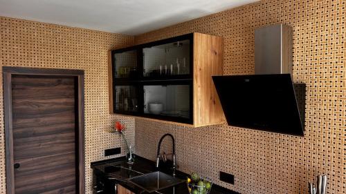 a kitchen with a sink and a tv on a wall at Jacaranda stylish ambiance with volcano and ocean views in Tacoronte
