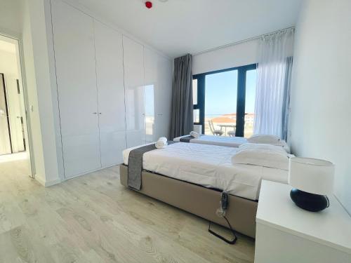 a bedroom with a large bed and a large window at Apartamento T1 - MedSal Residence in Santa Maria