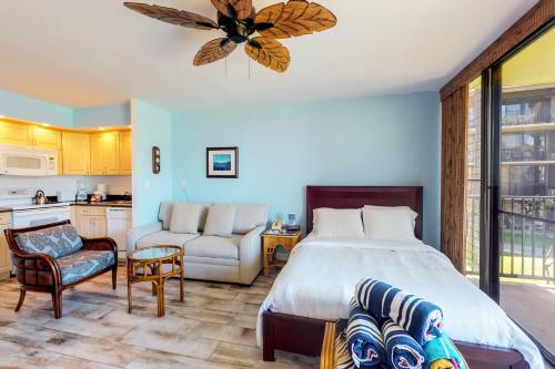 a bedroom with a large bed and a kitchen at Papakea Resort C204 in Honokowai