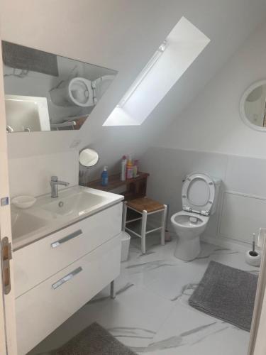 a white bathroom with a sink and a toilet at Jolie maison à mesquer in Mesquer