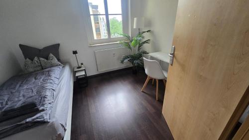 ein Schlafzimmer mit Bett, Schreibtisch und Fenster in der Unterkunft 3-Raum-Wohnung beim Luther in Chemnitz