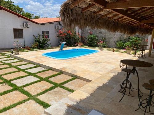 a swimming pool in a backyard with a table and chairs at Brisa Mansa in Barra Grande