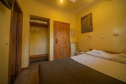 a bedroom with a bed and a wooden door at GK Pansion in Kruševac