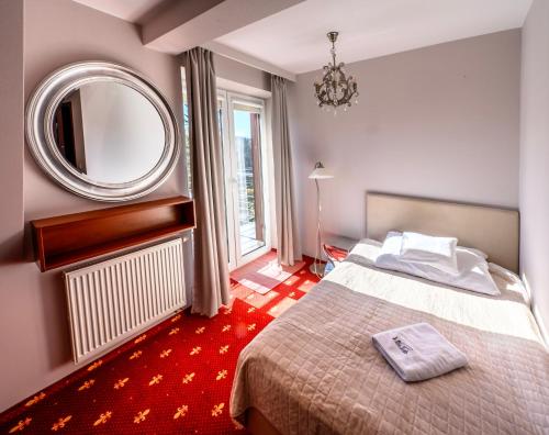a hotel room with a bed and a mirror at Villa Park in Bukowina Tatrzańska