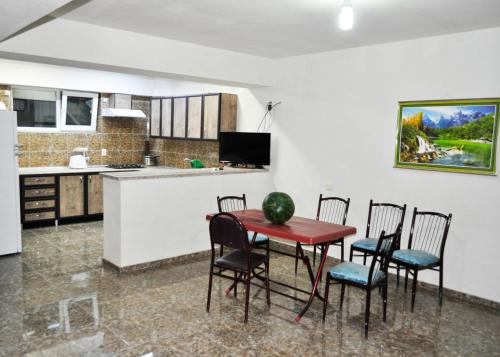 uma cozinha com mesa e cadeiras num quarto em Guest House Passiflora პასიფლორა em Grigoleti