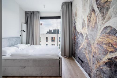 a bedroom with a bed and a painting on the wall at Towarowa Towers SkyLine View in Warsaw