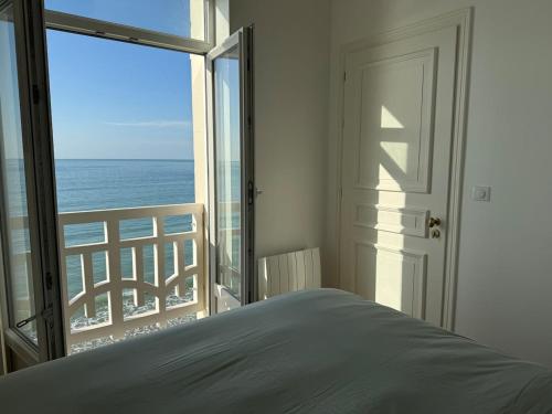 a bedroom with a bed and a view of the ocean at Vue Mer Panoramique - Appartement d'Exception in Wimereux