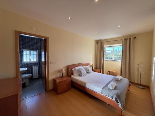 a bedroom with a large bed and a bathroom at Gouveia Forest Guest House in Gouveia
